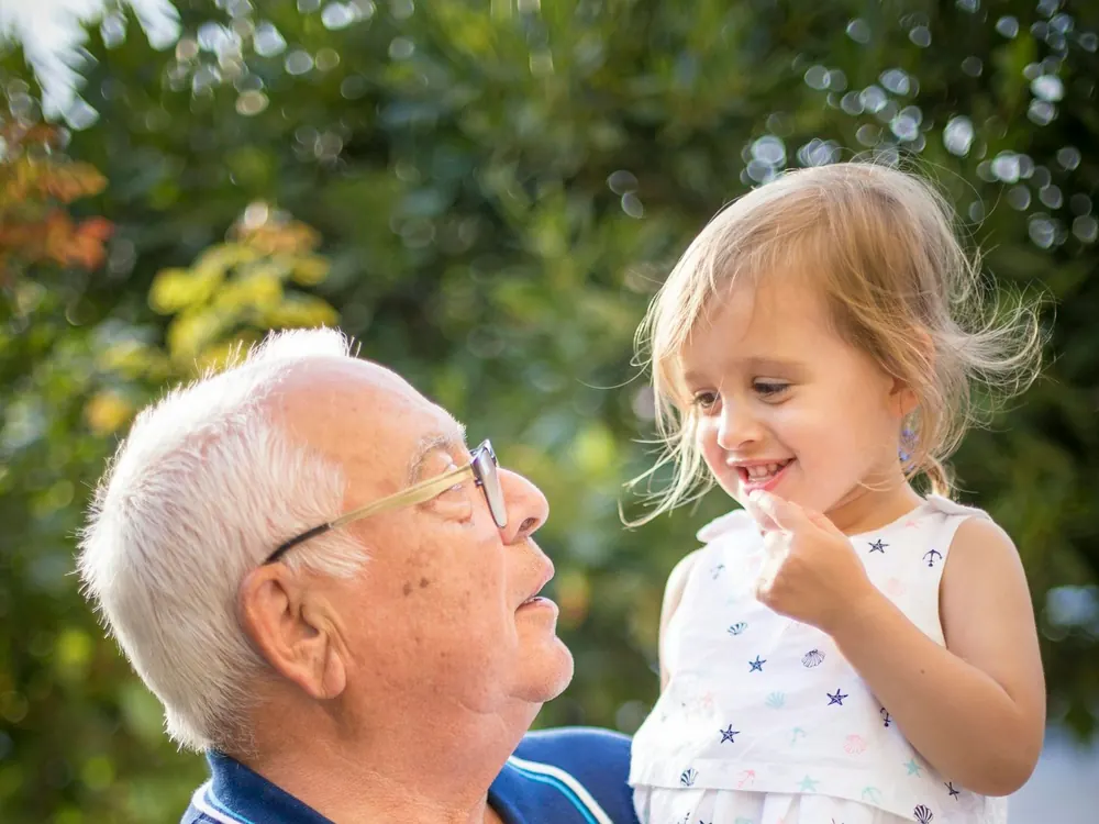 Un grand-père tient sa petite-fille dans ses bras