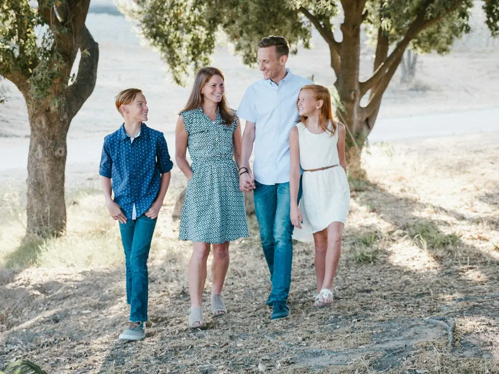 Une famille recomposée se promène ensemble sous les arbres